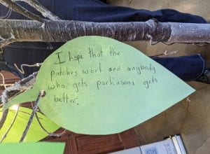 A green paper leaf with hand-written message reading: I hope that the patches work and anybody who gets Parkinsons gets better.